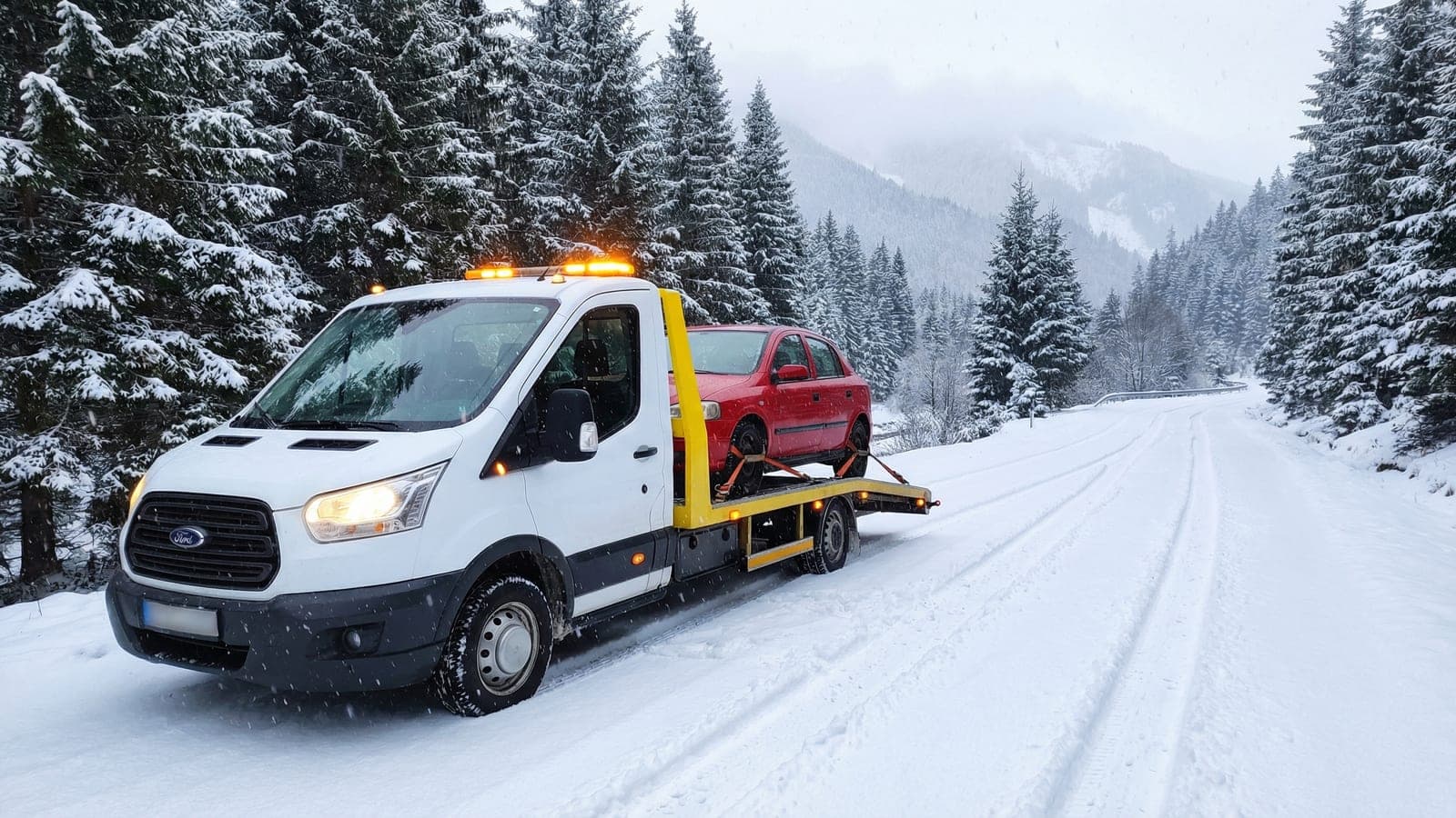 Tractare auto pe drum de munte cu zăpadă